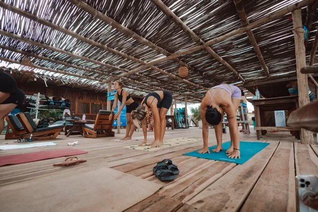 Participants practicing yoga on the beach during Kite Fest Guajira in Mayapo, La Guajira.